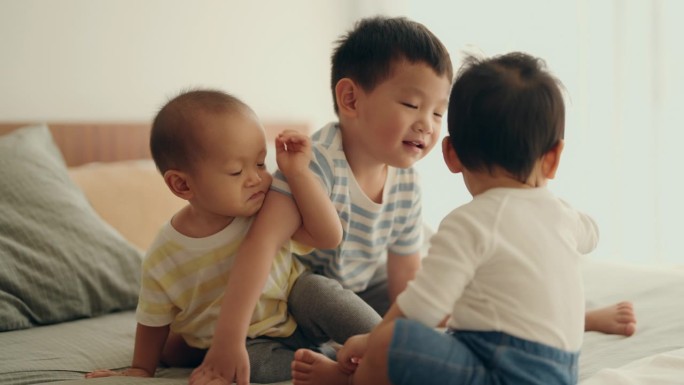 亚洲小男孩和小弟弟在家里的床上亲密无间:家庭团聚的快乐时刻
