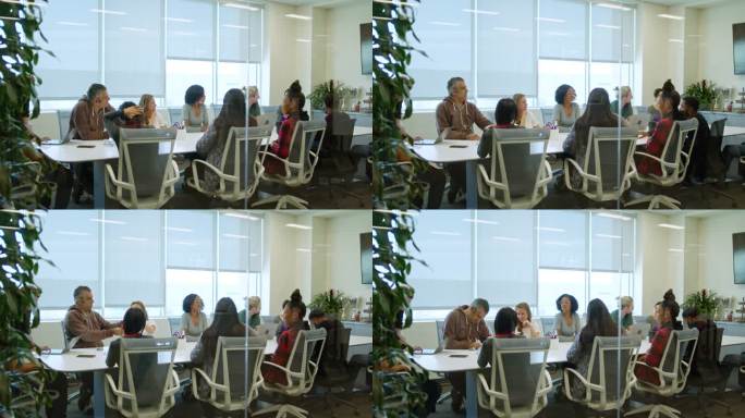 一群不同的工人在会议室里互相交谈的镜头