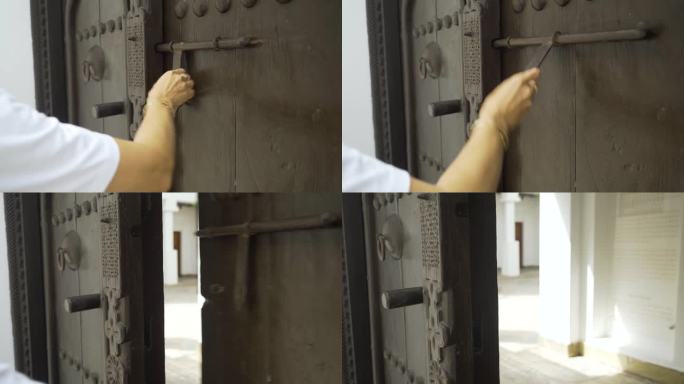在巴林，一名妇女敲开了一扇古老的传统木门