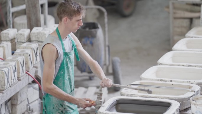 陶瓷厂的工人将液态粘土倒入模具中