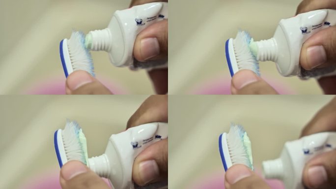 一双手把牙膏涂在破旧的牙刷上