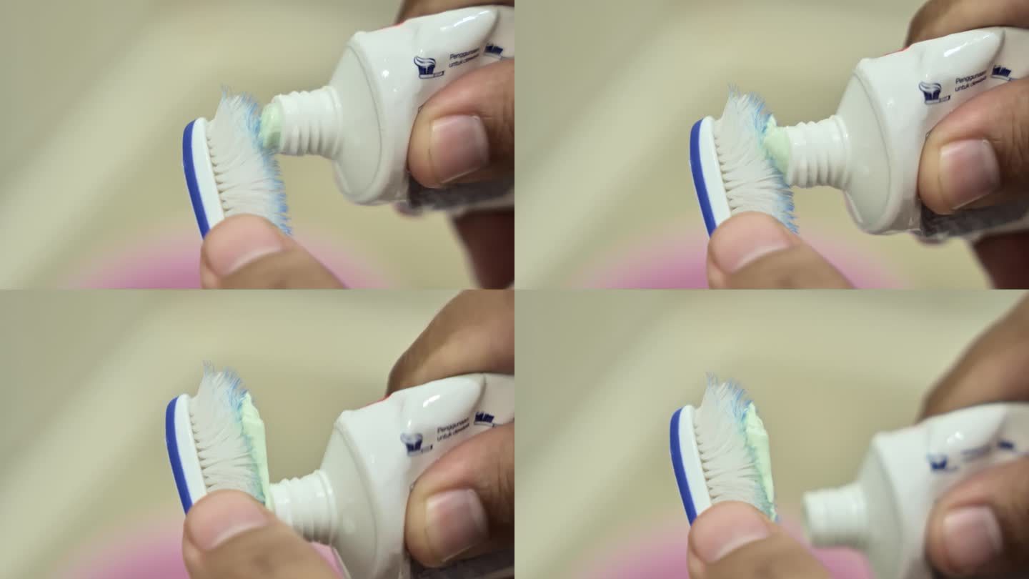 一双手把牙膏涂在破旧的牙刷上