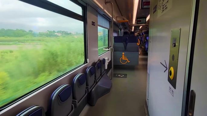 运动中的蓝色座椅现代火车。车厢内残疾人专用场所