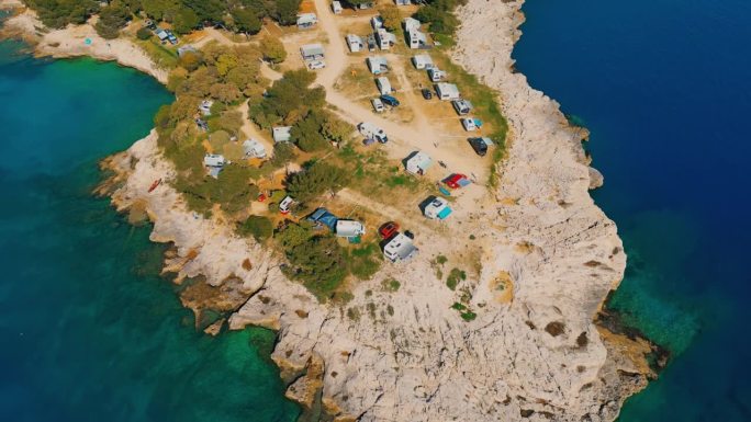 无人驾驶露营车停在岩石海岸和蓝色大海的海岸露营地