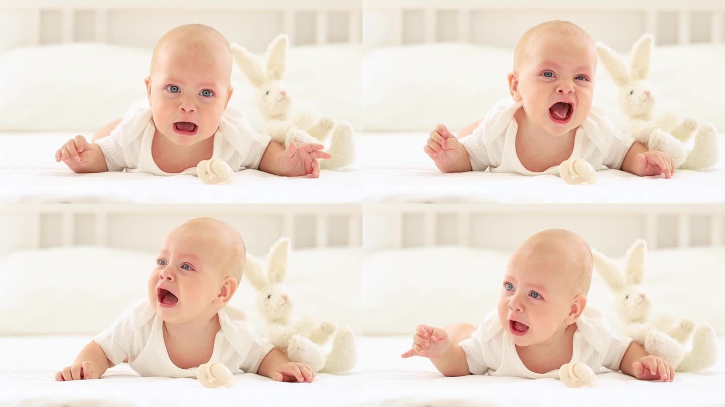 在明亮的卧室里，一个穿着白色紧身衣的婴儿在床上哭泣，一个蓝眼睛的可爱婴儿趴在地上叫他的妈妈，一个孩子