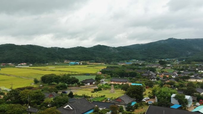 鸟瞰有传统韩国房屋的农村地区。韩国以山脉为背景的无人机视图