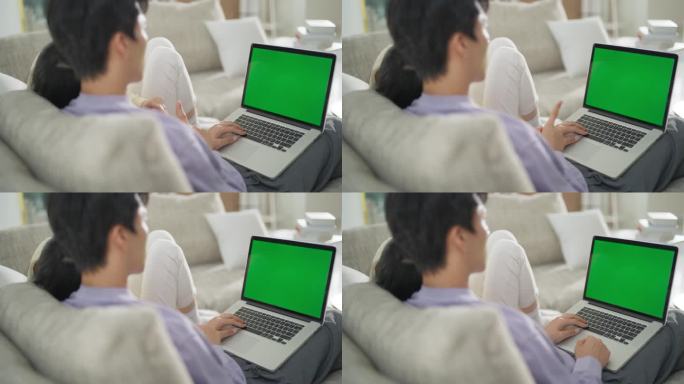 这是一对韩国夫妇在舒适的公寓里一起度过的时光，他们在一台绿屏模拟显示器的笔记本电脑上上网和搜索信息