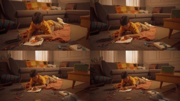 可爱的韩国男孩躺在地板上，用钢笔，铅笔，水彩画在笔记本上，在舒适的公寓里，温暖的光线。未来的艺术家是