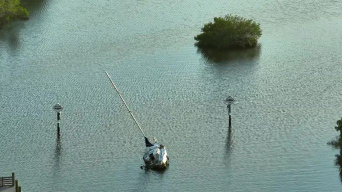 飓风伊恩袭击佛罗里达州马纳索塔后，半艘沉没的帆船在浅水湾水域倾覆