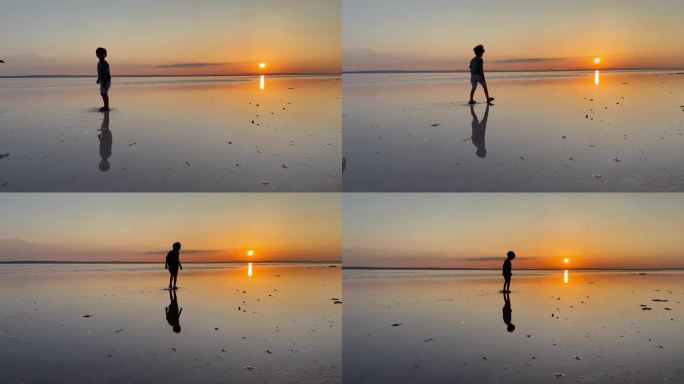 日落时分，小男孩在盐湖上朝着太阳走去。