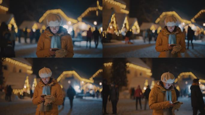 一名妇女走过圣诞市场时正在使用手机