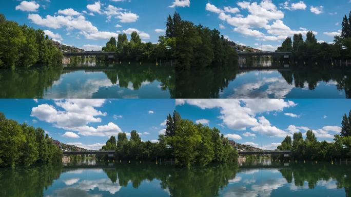 利马特河在瑞士苏黎世的欧洲大桥下流动。低角度看，阳光明媚的夏日，桥上来往的车辆，浮云飘过，河上漂浮着