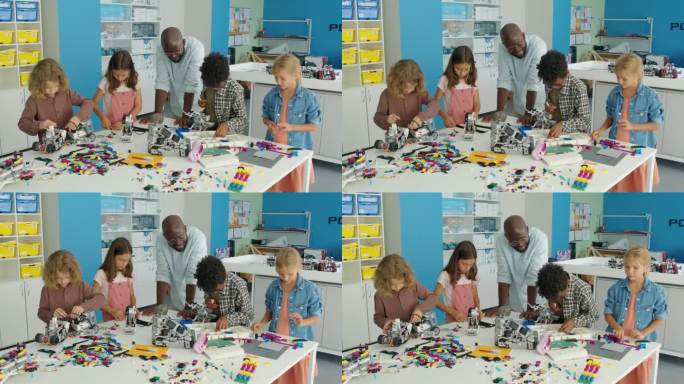 黑人男老师在爱好俱乐部观看不同的孩子制作玩具机器人