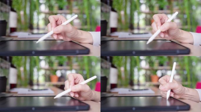 平板电脑上的电子签名，近距离手写商务女性合同协议，商务女性在办公室工作时使用触控笔在数字平板电脑上签