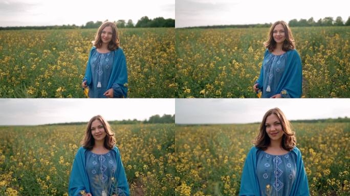 微笑的乌克兰妇女手持国旗，背景是黄色的油菜籽田。穿蓝色绣花衣服的小姐。乌克兰，独立，自由，爱国者的象
