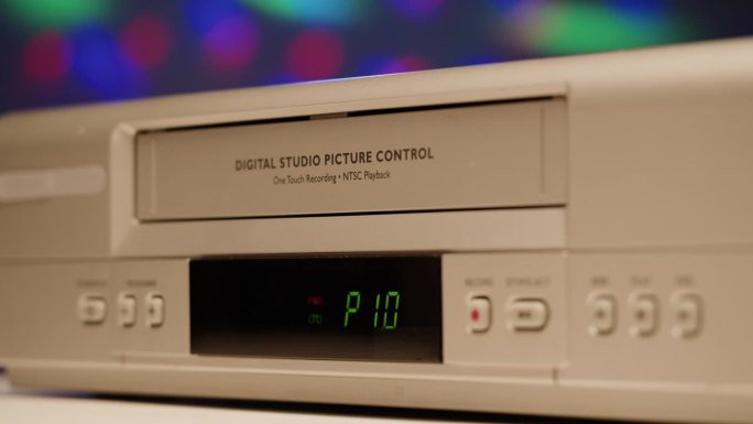 旧录像机的特写，VHS。复古播放器，在霓虹背景上播放的老式录像带，录音带，迪斯科舞会。