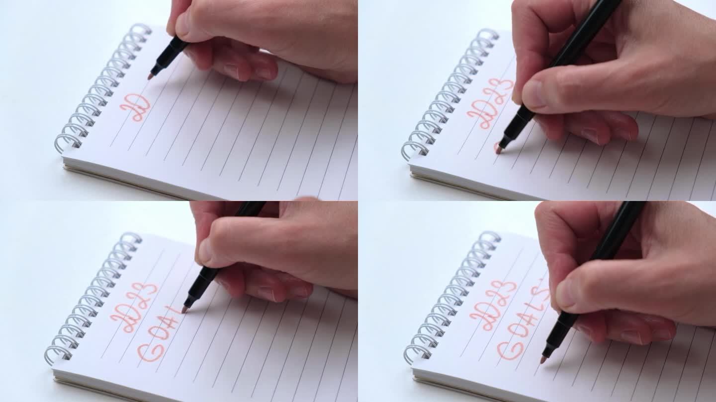 手特写，用粉红色的毡尖笔在笔记本上写下2023年的数字和来年的目标。
