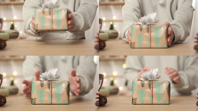 近距离用手工包装纸和鲜花装饰圣诞礼物，放在桌子上。为新年节日准备礼物。