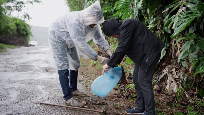 下雨天，人们把花园垃圾放进垃圾袋