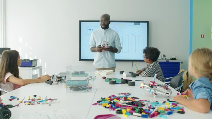 黑人男老师在机器人课上与孩子们交谈