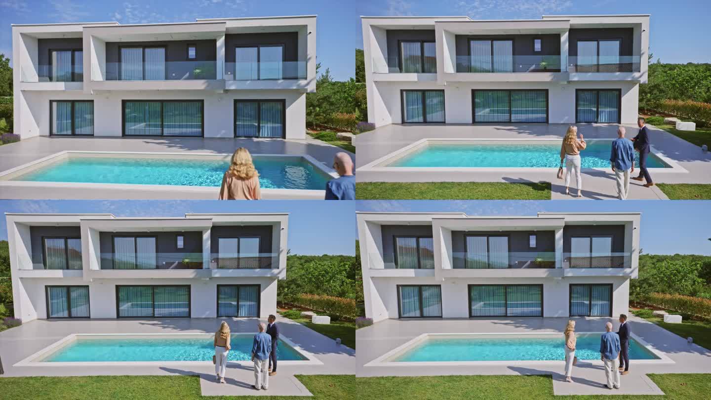 CS男房地产经纪人向一对夫妇展示一套带游泳池的现代住宅