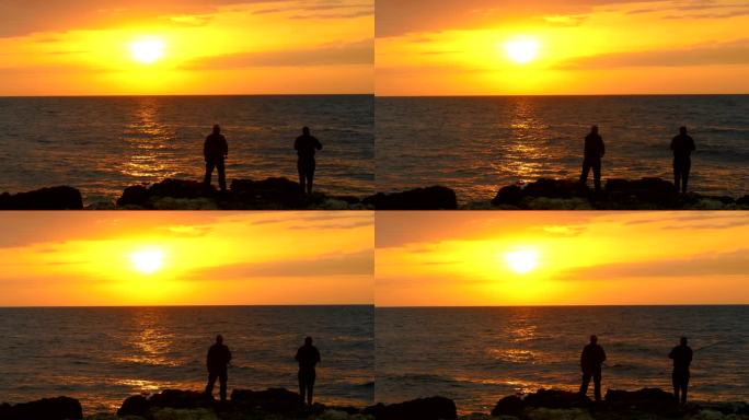 日落时在岸边钓鱼金色夕阳两个人站在海边天