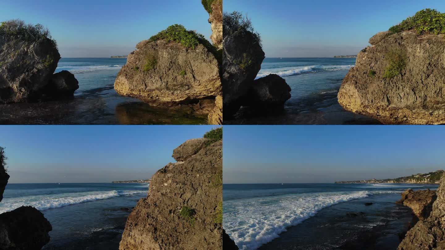 在一个阳光明媚的日子里，在海岸的两个大岩层之间飞行，被大自然包围。开阔的蓝色海洋和白色的波浪在背景中