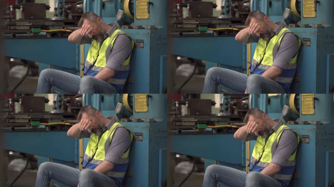 疲倦的高级工程师工人坐在工厂的机器上休息。胡子老男人的劳动手在额头上疲惫的工作。抑郁症员工倦怠。