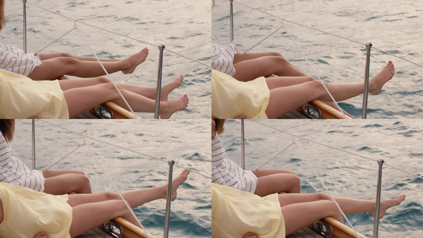 女朋友的腿挂在边缘帆船在海洋上奢侈的生活方式快乐的冒险旅行度假