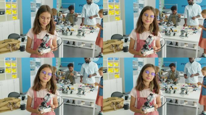年轻快乐的女孩在儿童科学俱乐部与机器人模特合影
