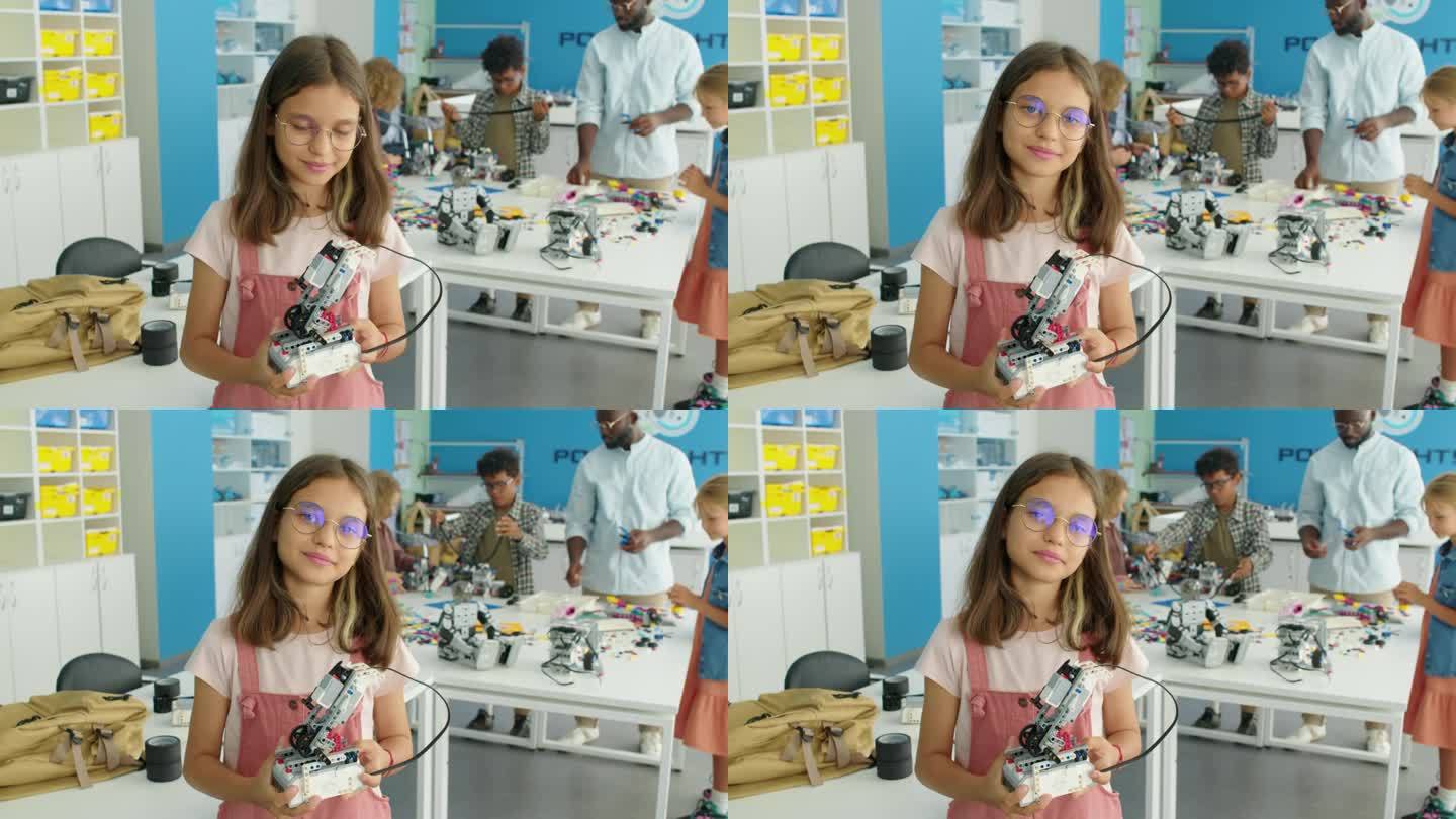 年轻快乐的女孩在儿童科学俱乐部与机器人模特合影