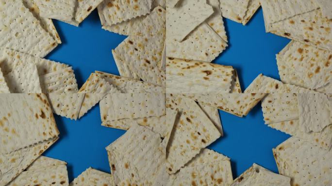无酵饼或无酵饼犹太食品蓝色背景与大卫星。犹太人传统的逾越节面包。逾越节的庆祝标志。4K视频，旋转