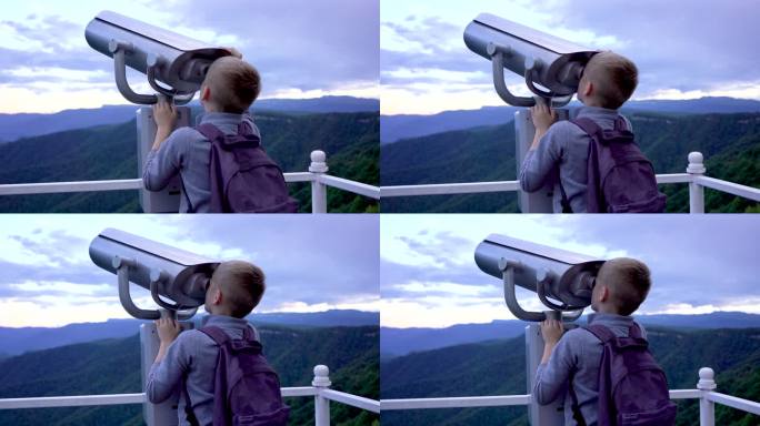 男孩好奇地透过望远镜往外看。山看。用双筒望远镜看天空。和孩子一起旅行。和学生们有趣的旅行。在山上远足