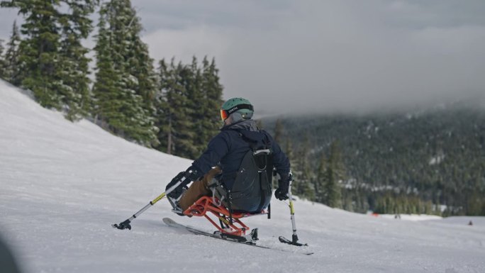 自适应运动员坐滑雪手持伸出