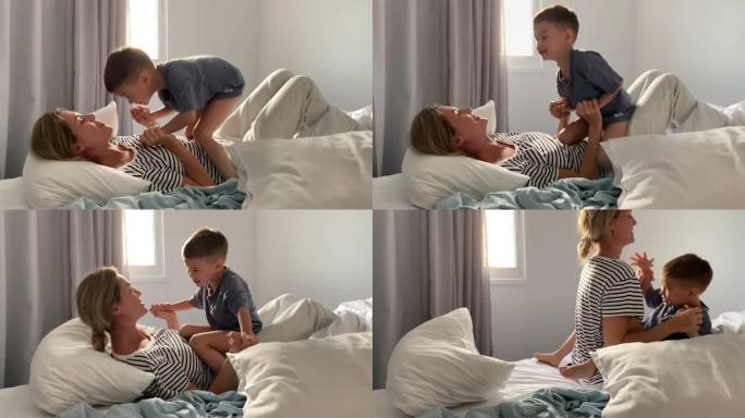 喜出望外的小男孩和他的妈妈进行了枕头大战。团聚和快乐童年的概念