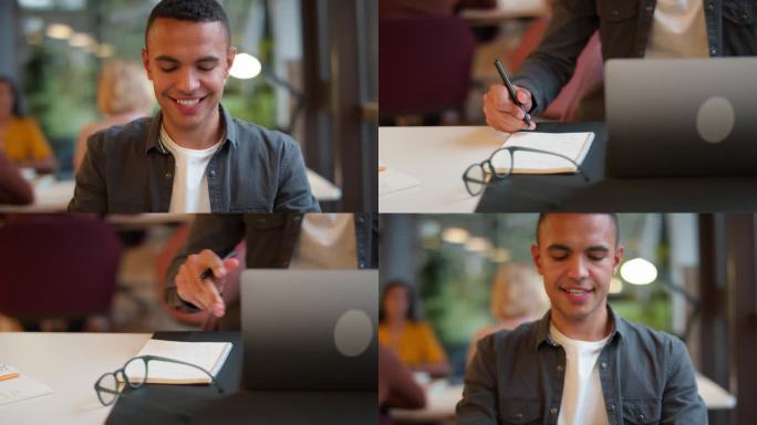 年轻的商人在办公室的桌子上用笔记本电脑做笔记