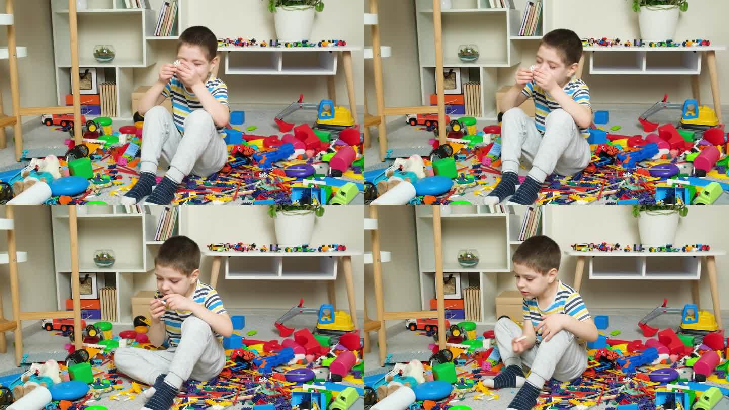 小男孩坐在地板上玩玩具，玩具堆得乱七八糟，孩子们的房间一片狼藉