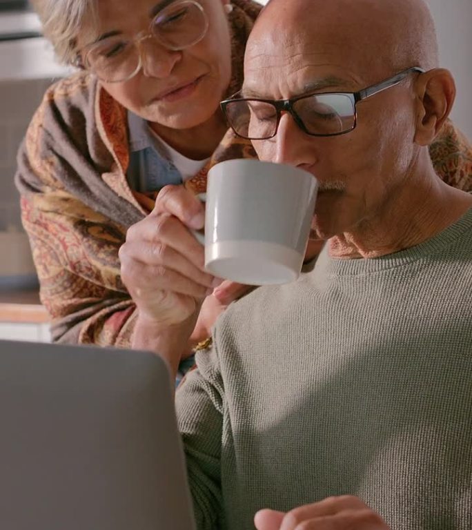 老年夫妇，在家里用笔记本电脑上网聊天，喝咖啡，网购。老年妇女和男子坐在餐桌上，用电子邮件、新闻或讨论