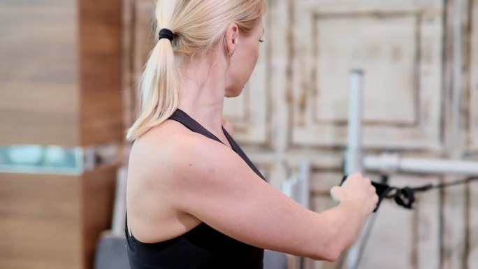 普拉提课程在现代工作室金发教练加强手臂肌肉的改革