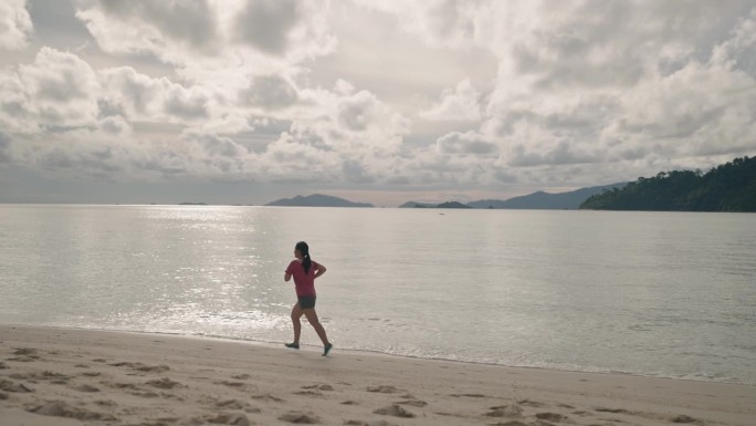 女子在沙滩上跑步锻炼