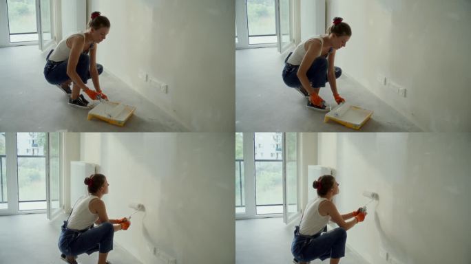 女人在画她梦想中的房子墙壁。穿戴防护服和护目镜
