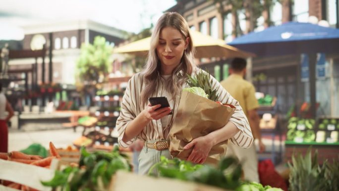 时尚女性顾客使用智能手机，在网上查看食材清单，并在社交网络上查看美味的晚餐食谱。美女从街边小贩那里买