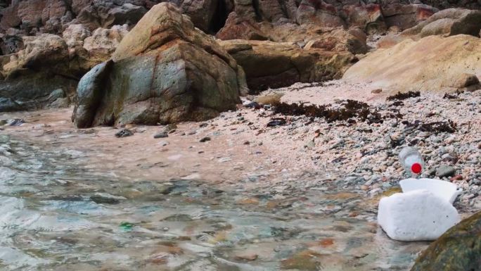 海滩上的塑料碎片。悲伤的照片与美丽壮丽的海洋自然中散落的海滩的苦涩对比，唤起了对全球变暖的不安和根深