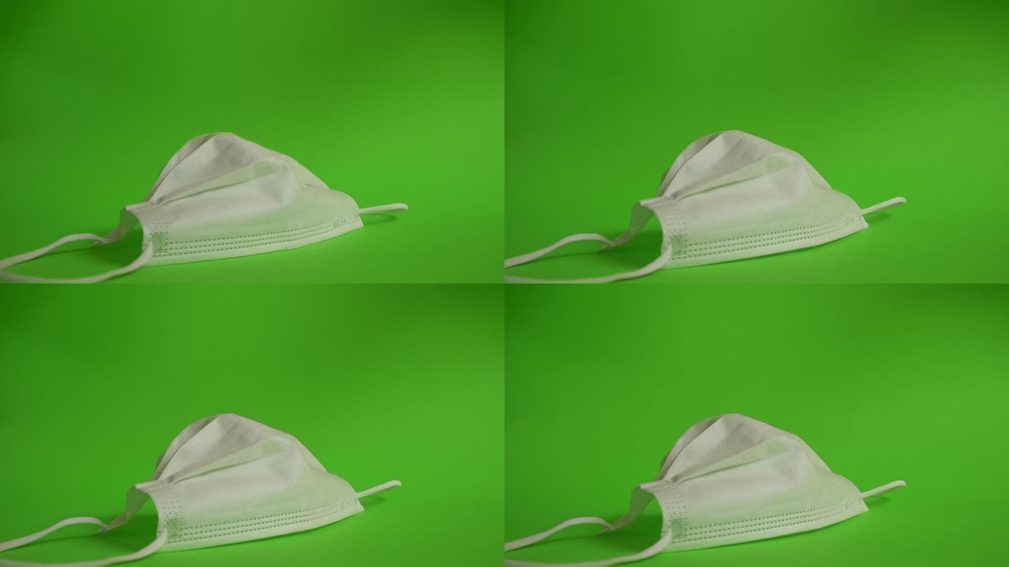 慢镜头，医用卫生外科口罩掉落在绿色屏幕上