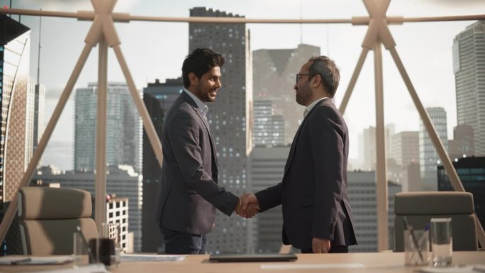 两个印度商业伙伴在办公室见面，握手。公司总裁和财务经理在市办公室开会。商务人士前来洽谈房地产购销项目