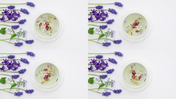 健康的花草茶装在白色的茶杯里，用中药、花和中国玫瑰花蕾制作而成