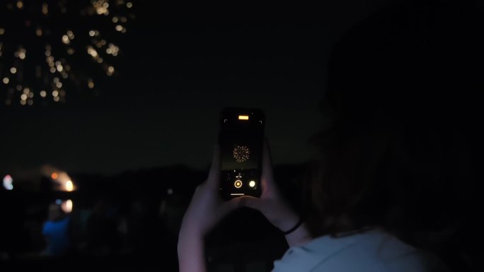 用手机相机拍摄烟花。夜空中的烟花适合在7月4日或新年庆祝活动。
