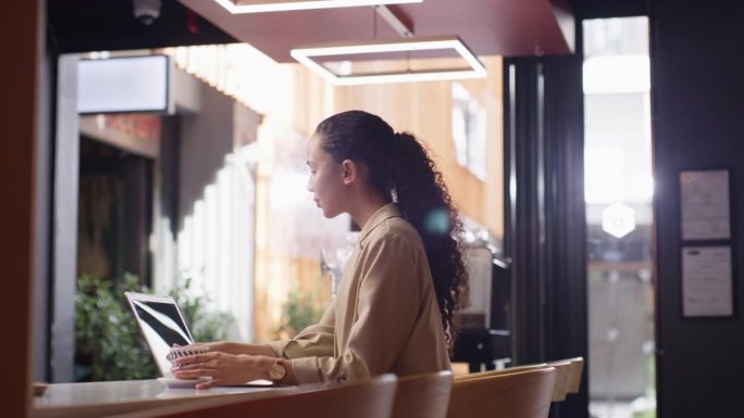 笔记本电脑，研究和一个女企业家在咖啡馆远程工作的一个项目作为自由职业者。电脑，咖啡馆和一个在餐馆工作