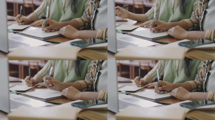 学生在校学习时，女生在桌上用笔记本电脑写笔记的特写