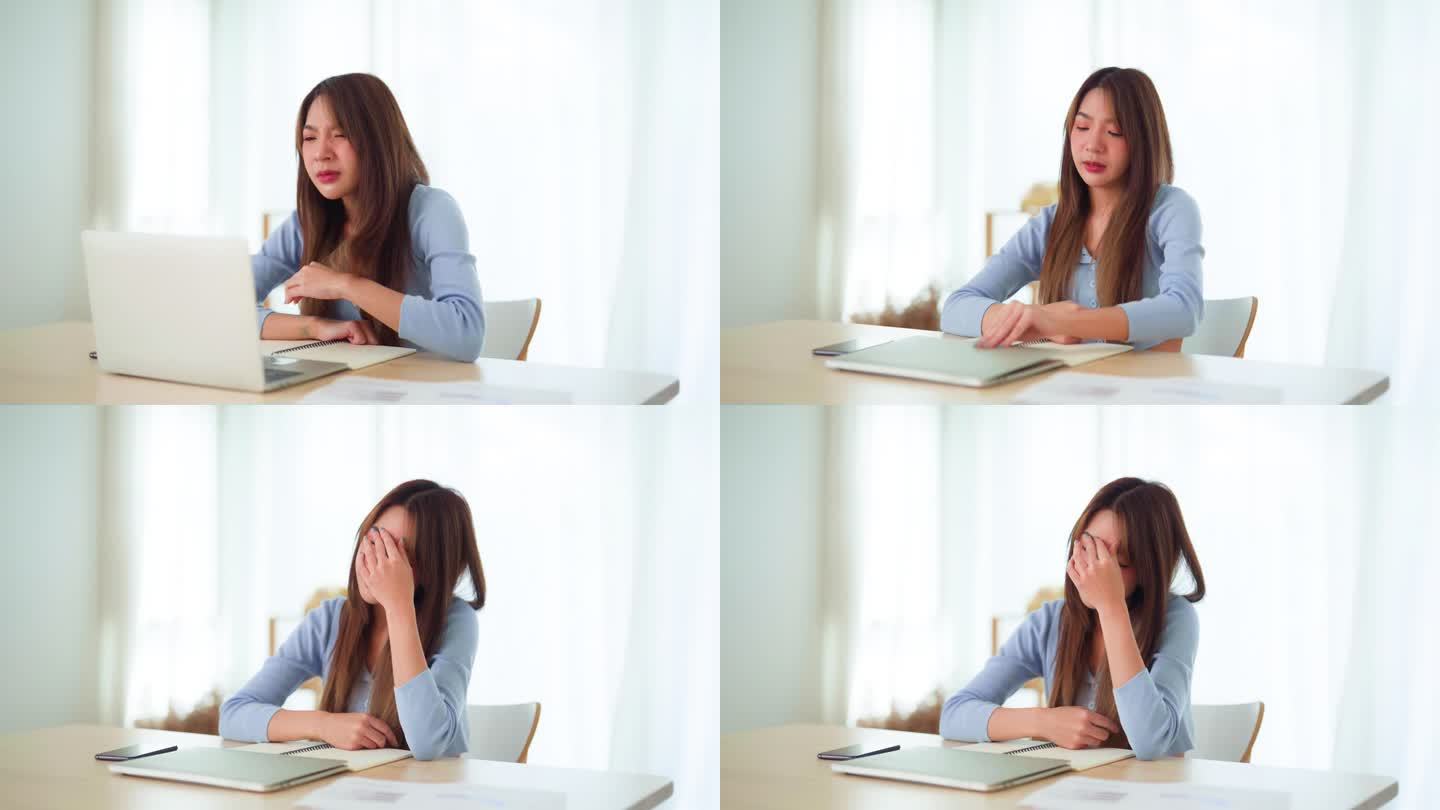 办公室综合症。劳累过度的年轻亚洲女性在电脑工作后感到头痛和视力问题。紧张的年轻女子在家里饱受疲劳之苦